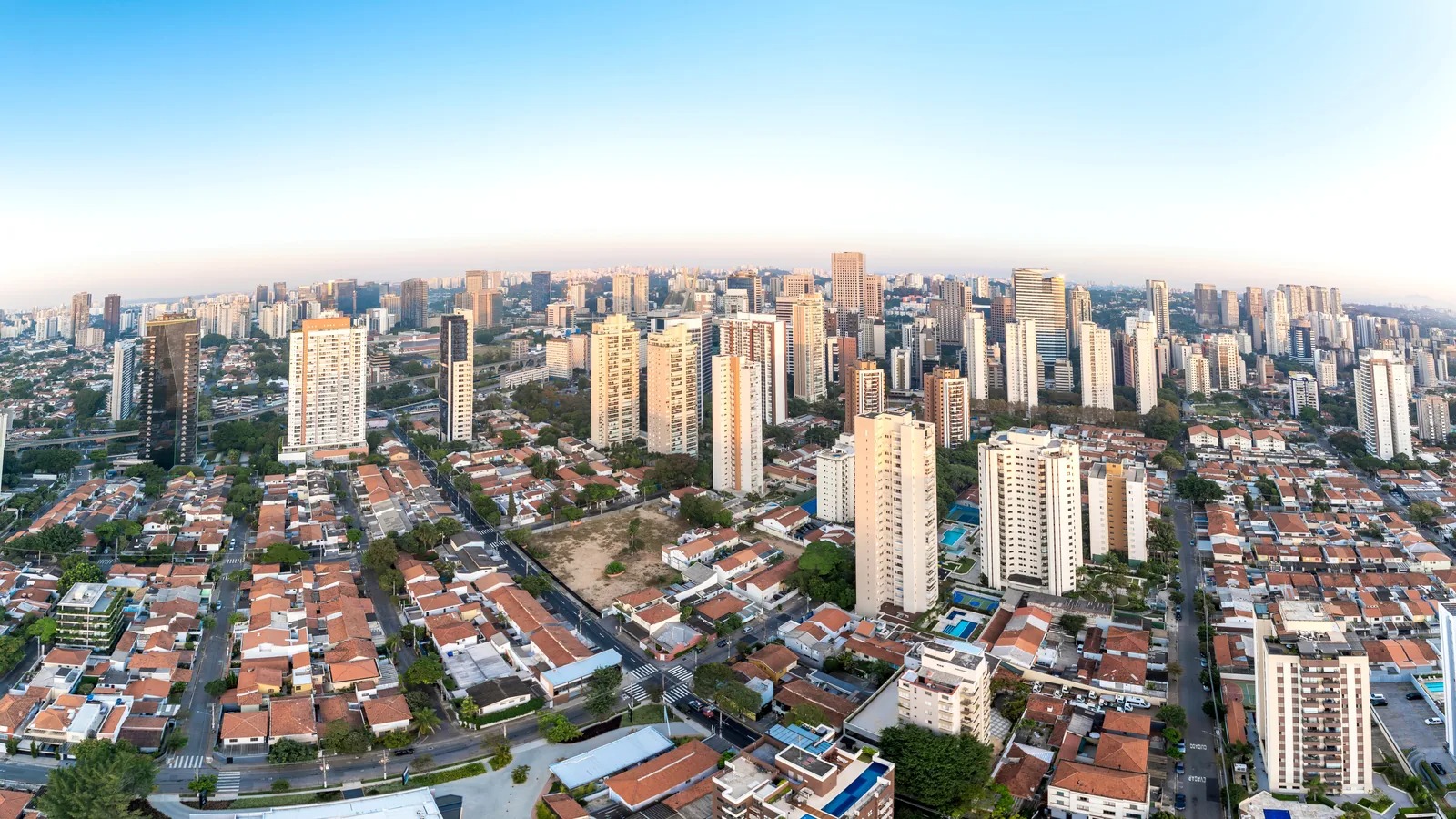 Vista aérea do Brooklin, em São Paulo, com casas residenciais em primeiro plano e torres de apartamentos ao fundo