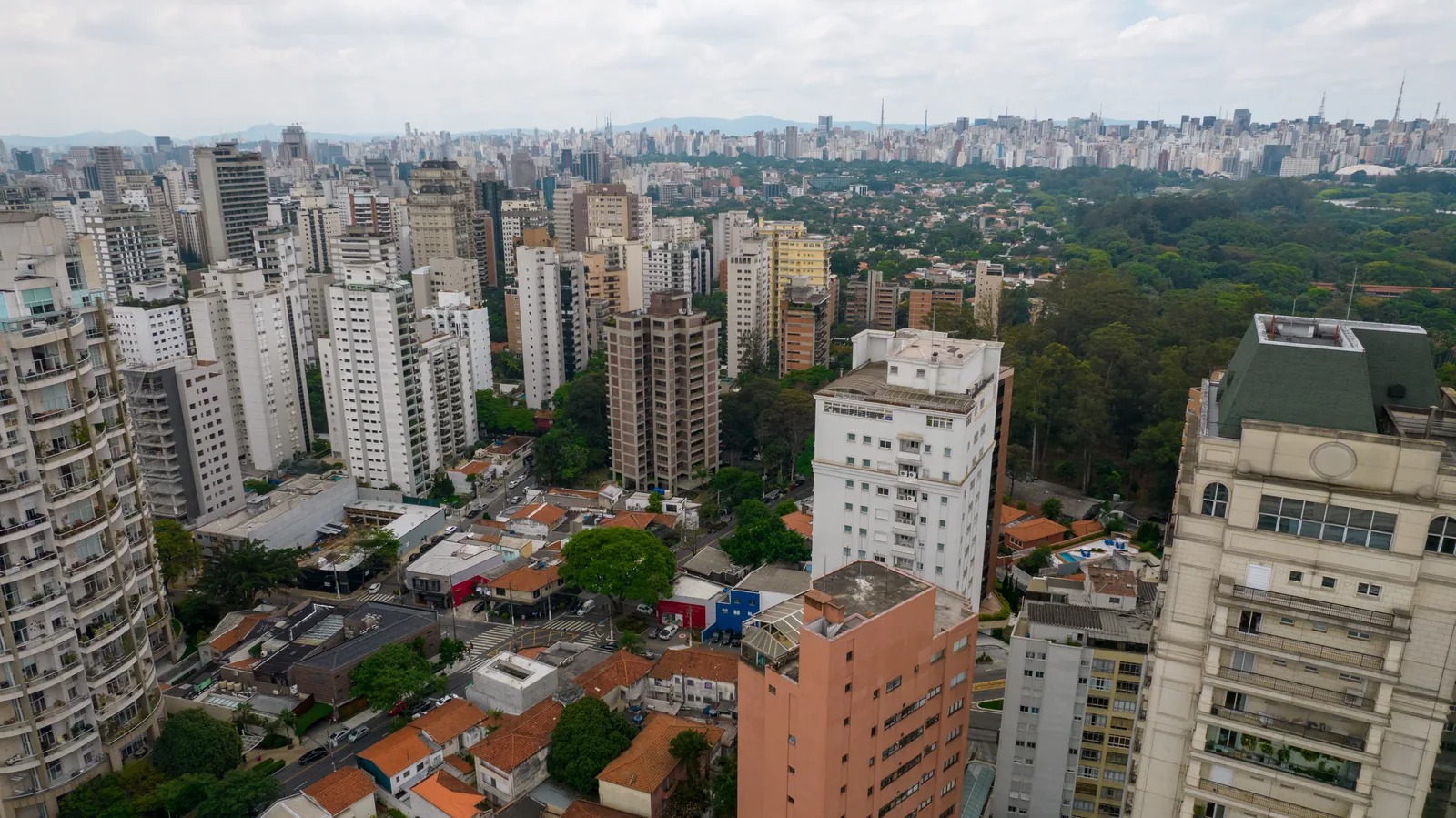 Vista aérea da Vila Nova Conceição, em São Paulo, com prédios residenciais e a área verde do Parque Ibirapuera ao fundo