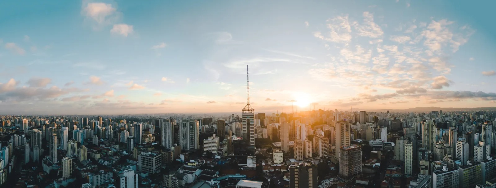 Vista panorâmica da cidade de São Paulo ao entardecer, com prédios residenciais da zona sul