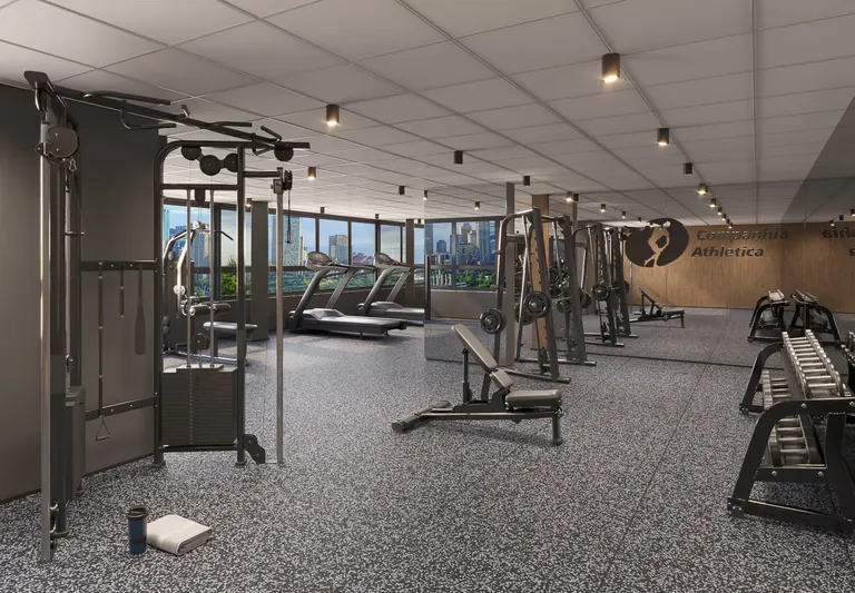 Vista geral da academia com equipamentos de musculação e pesos livres